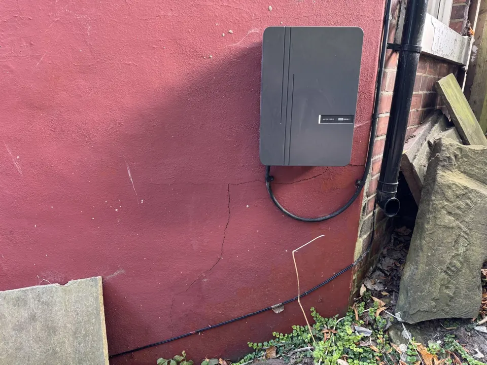Crack in external render running down to ground level below a wall-mounted EV charger